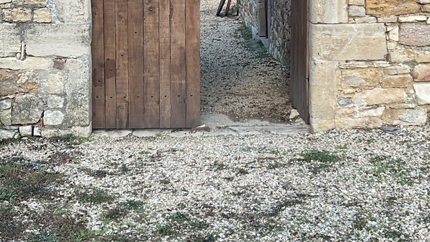 An arched stone doorway leading to a building with a tiled roof. - Loca saiso/vac/Séjour : 120 m² in an authentic, restored farmhouse (Goutrens)