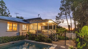 Une maison avec une piscine, une véranda et un jardin clôturé.