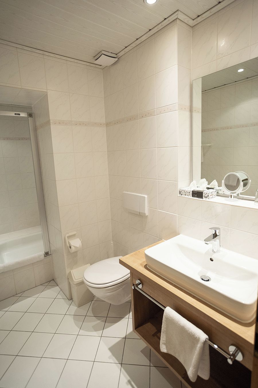 Ein modernes Badezimmer mit Toilette, Waschbecken und Spiegel.