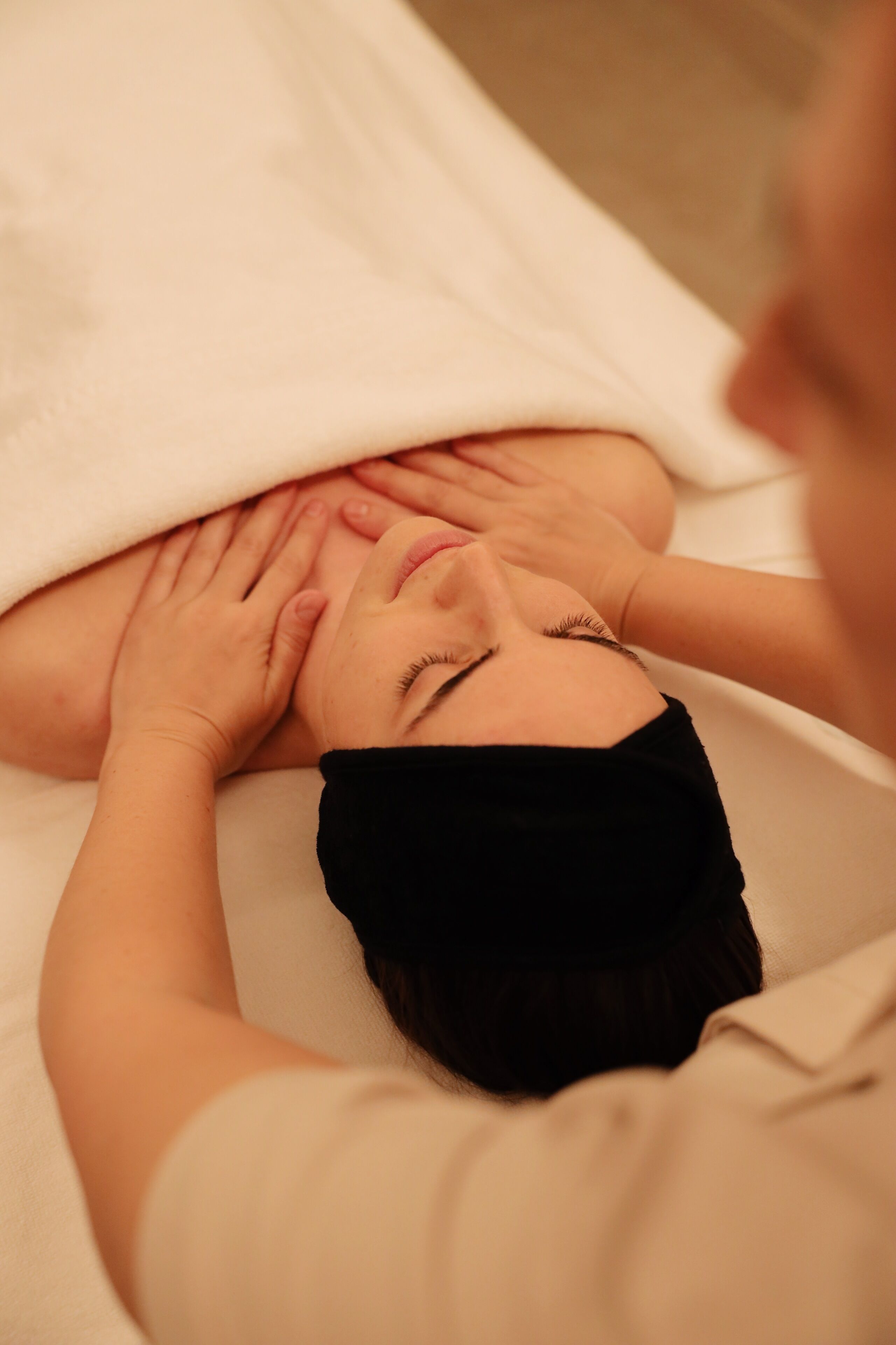 Une personne allongée sur un lit en train de recevoir un massage.