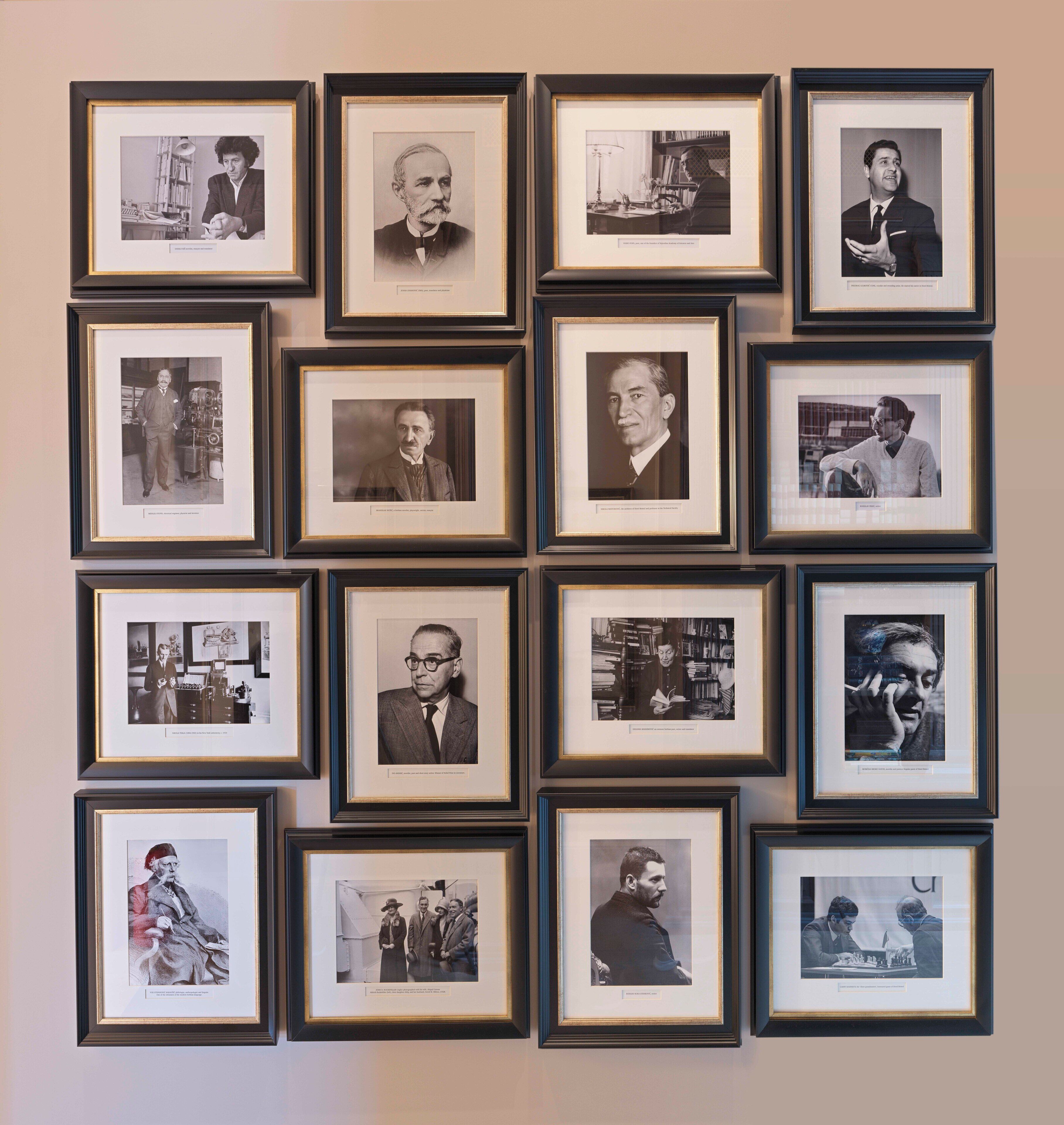 A wall of framed photographs in a gallery setting.