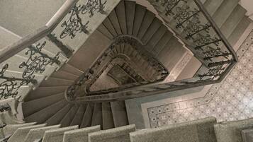 A grand staircase with ornate metal railings and a decorative ceiling.