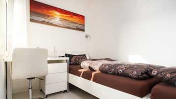 Ein Schlafzimmer mit einem Bett, einem Schreibtisch und einem Stuhl.