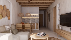 A modern living room with a sofa, coffee table, and a TV. There is a kitchen area with a dining table and chairs. - Africa Safari Nyerere (Selous Game Reserve)