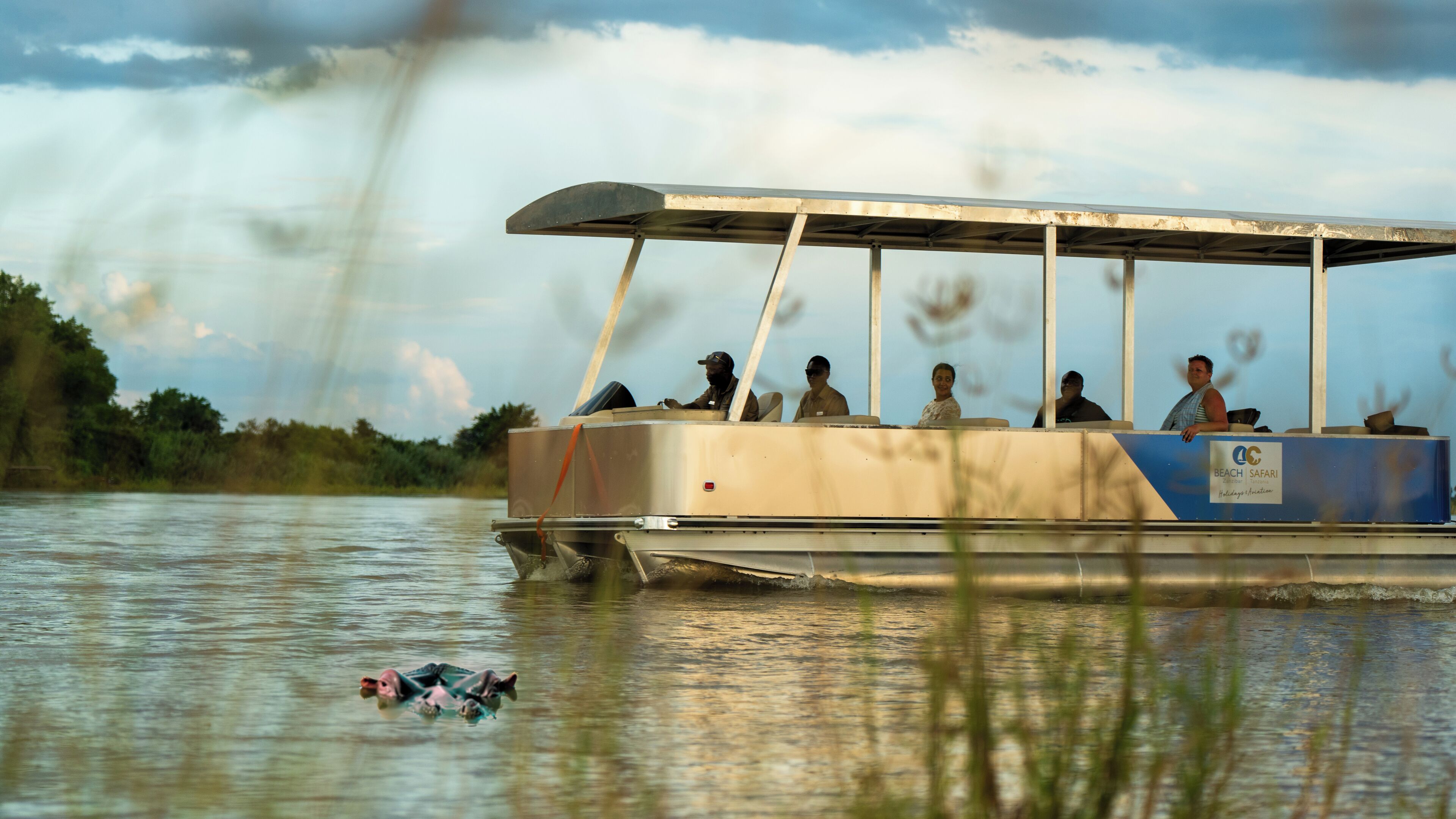 A boat with a covered deck and a sign reading "Beach Safari".