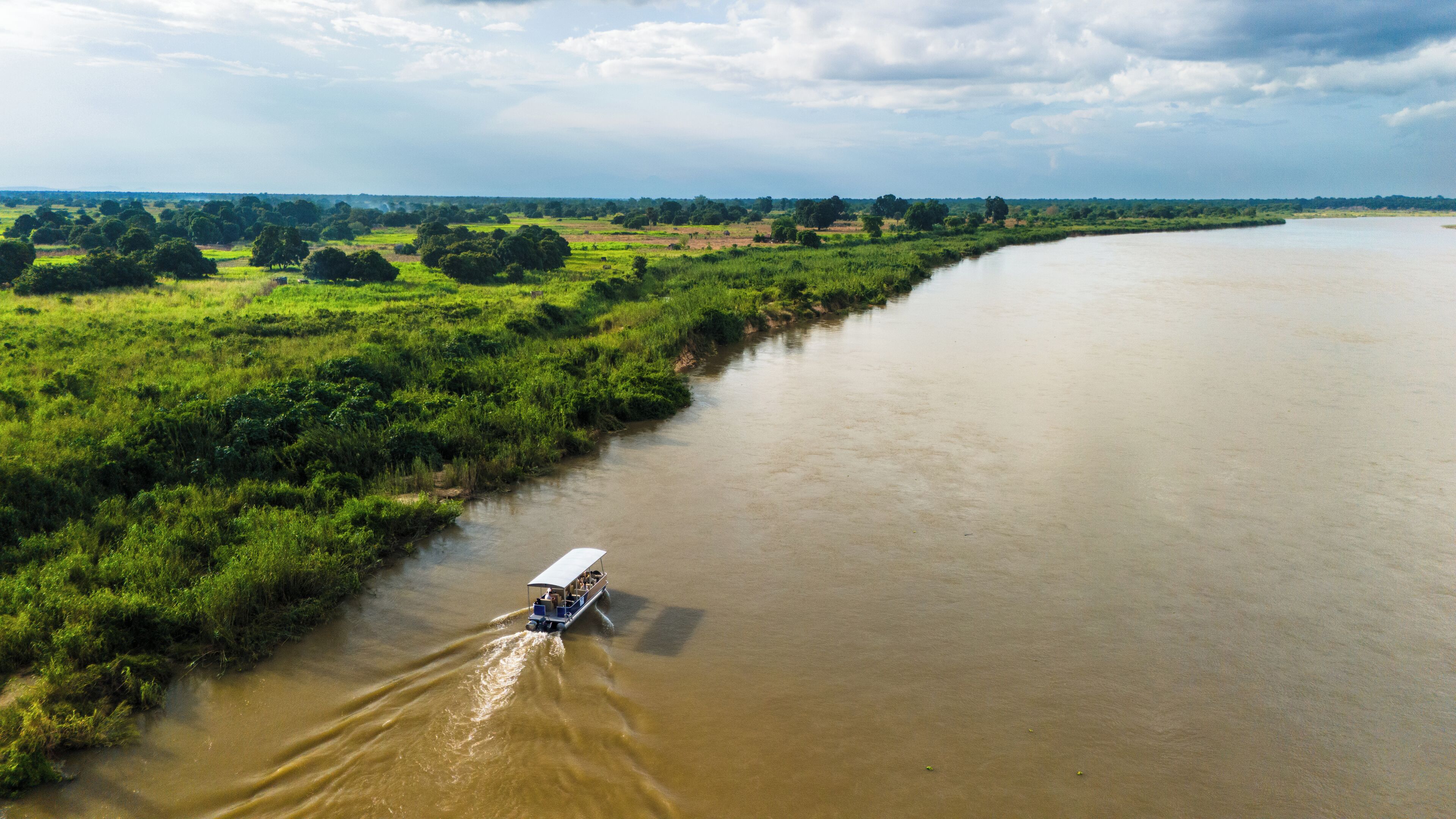 A river with a boat moving along the water.