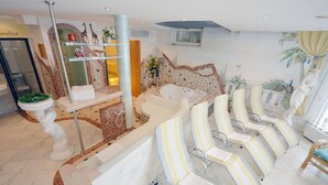 A spa area with a reception desk, a large bathtub, and several striped lounge chairs. - Apartment in Arzl With Wellness Area (Arzl im Piztal)
