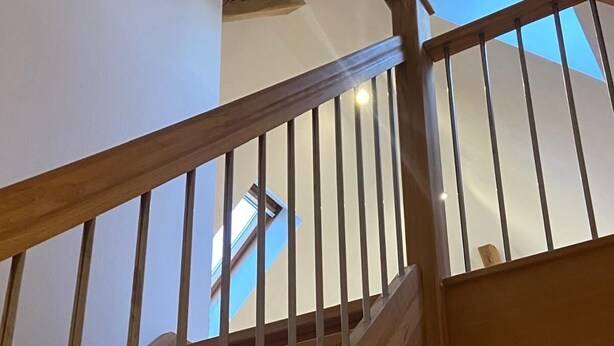 Una escalera de madera con techo de vidrio y tragaluz.
