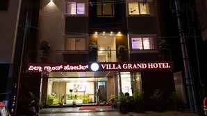 A multi-story hotel with a prominent sign reading "Hotel Villa Grand."