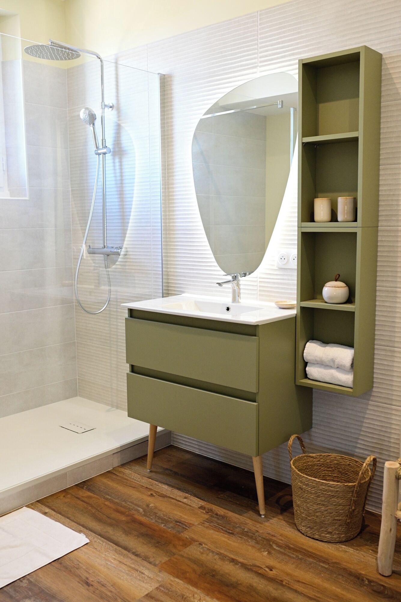 Een moderne badkamer met een douche, wastafel en opbergplanken.