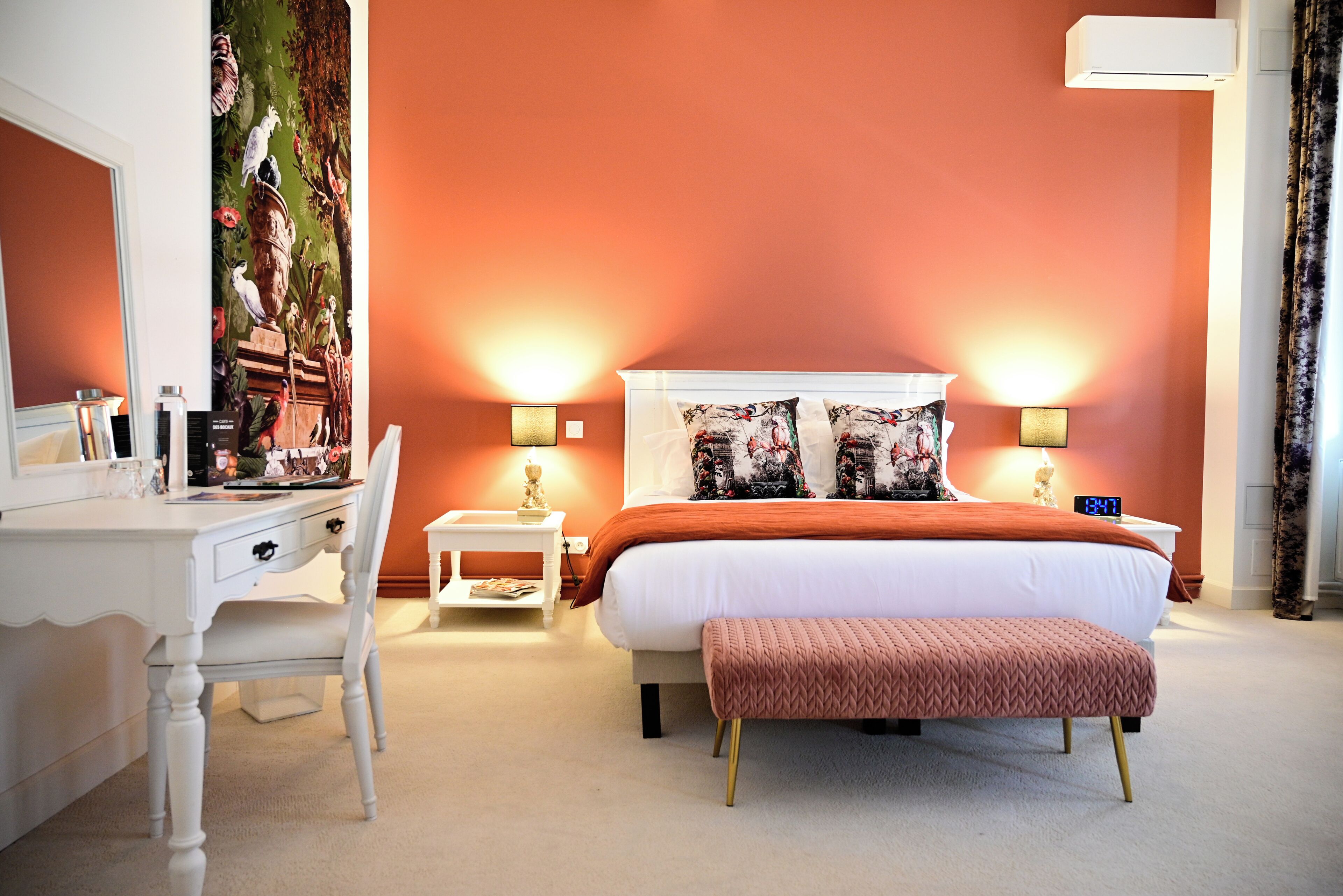 Une chambre à coucher comprenant un lit, des tables de chevet, un bureau et une chaise.