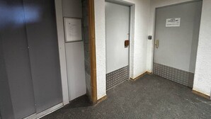 A hallway with three doors, one of which has a sign indicating a local business. - Apartment 5 pers, parking, Plagne Soleil (Plagne Soleil)