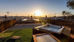 A hot tub and lounge chairs in a backyard with a marina view. - Appart Hotel | 3 bedrooms | Parking | swimming pool (Saint Raphaël)