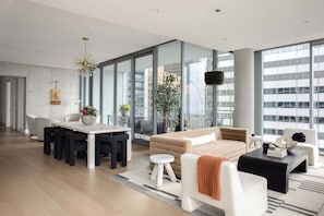 A modern living room with a sofa, coffee table, and dining area.