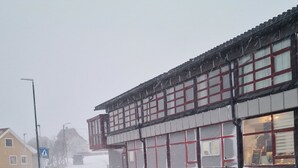 A building with large windows and a snow-covered street. - Mehamn Arctic Hotell AS (Gamvik)