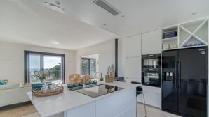 Una cocina moderna con una isla central, electrodomésticos integrados y vistas al exterior.