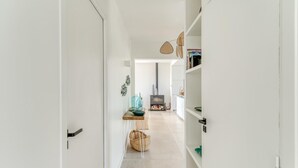 A hallway with a wooden table, a basket, and a bookshelf.