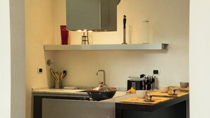 Una cocina moderna con estufa integrada, un lavamanos y una encimera con varios utensilios de cocina.