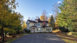 A two-story house with a driveway leading to the front door.