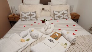 Un letto rifatto con cura, con una testiera, numerosi cuscini e un cuscino decorativo con la scritta 'love'.