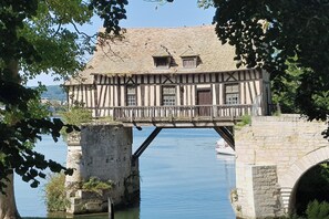 A traditional half-timbered house with a stone bridge over a river. - Celies Country Cottage near Giverny (blaru)