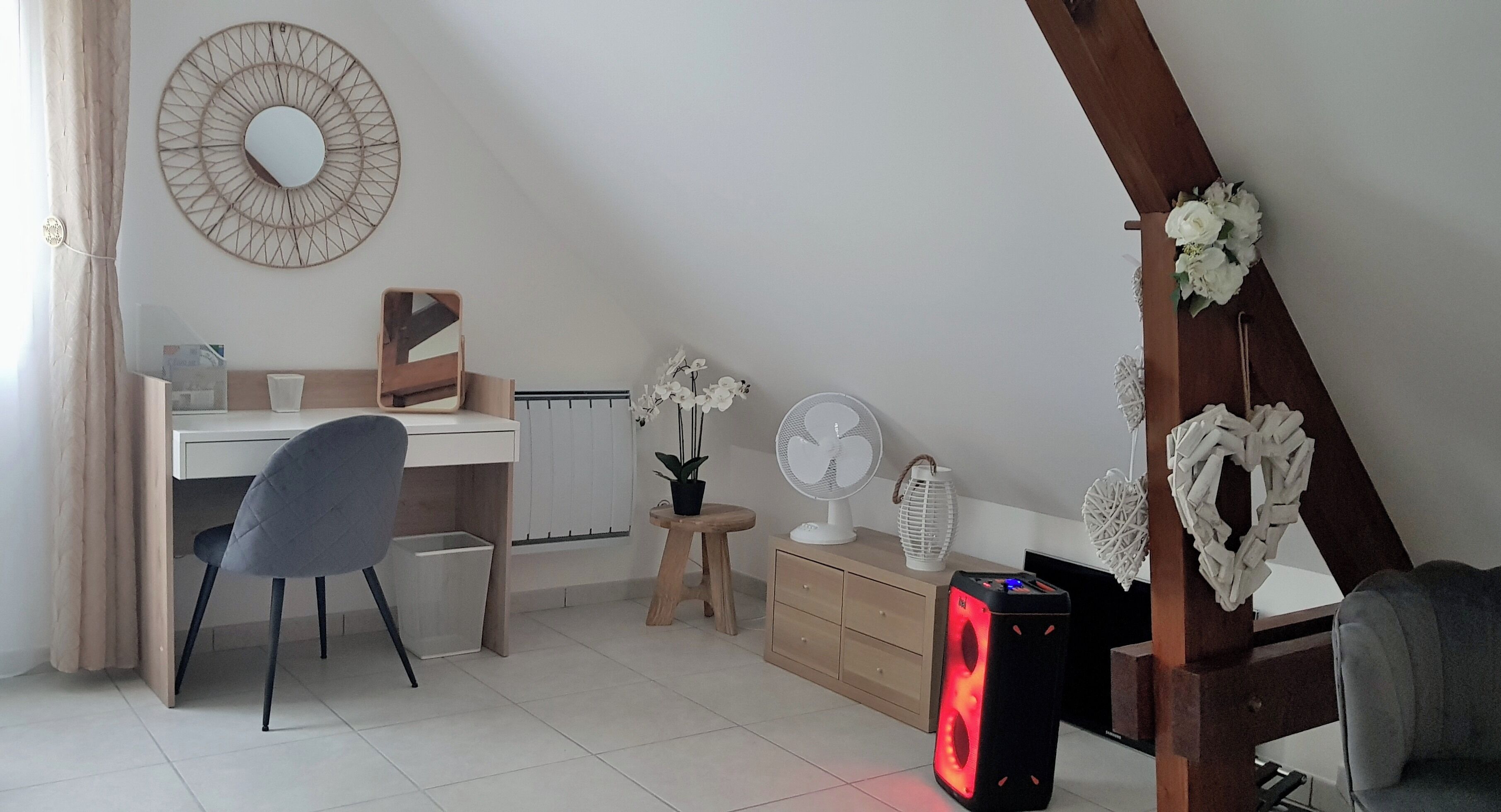 Une pièce comprenant un bureau, une chaise et un radiateur mobile.