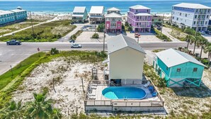 A coastal property with a swimming pool, a beach house, and a main building with a balcony. - Gulf view retreat w/ Private pool at Summer Salt! (Gulf Shores)