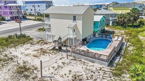 A two-story house with a swimming pool, surrounded by a sandy beach and a road. - Gulf view retreat w/ Private pool at Summer Salt! (Gulf Shores)