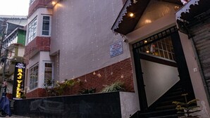 A multi-story hotel with a prominent entrance, a staircase, and a sign indicating it is a hotel. - Hotel Raj Ville (Darjeeling)