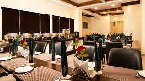 A dining area with tables set for service, equipped with buffet stations and a variety of food containers. - Hotel Raj Ville (Darjeeling)