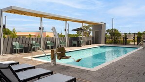 A swimming pool with lounge chairs and a covered seating area. - Home2 Suites By Hilton Austin South I-35 (Austin)