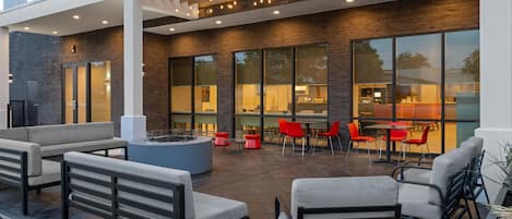 An outdoor seating area with modern furniture and a fire pit.