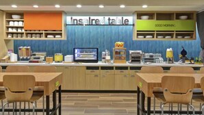 A breakfast area with a sign reading "Inspired table" and a "Good Morning" sign above a counter with various food items and a coffee machine. - Home2 Suites By Hilton Austin South I-35 (Austin)