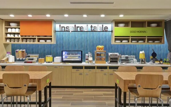 A breakfast area with a sign reading "Inspired table" and a "Good Morning" sign above a counter with various food items and a coffee machine. - Home2 Suites By Hilton Austin South I-35 (Austin)
