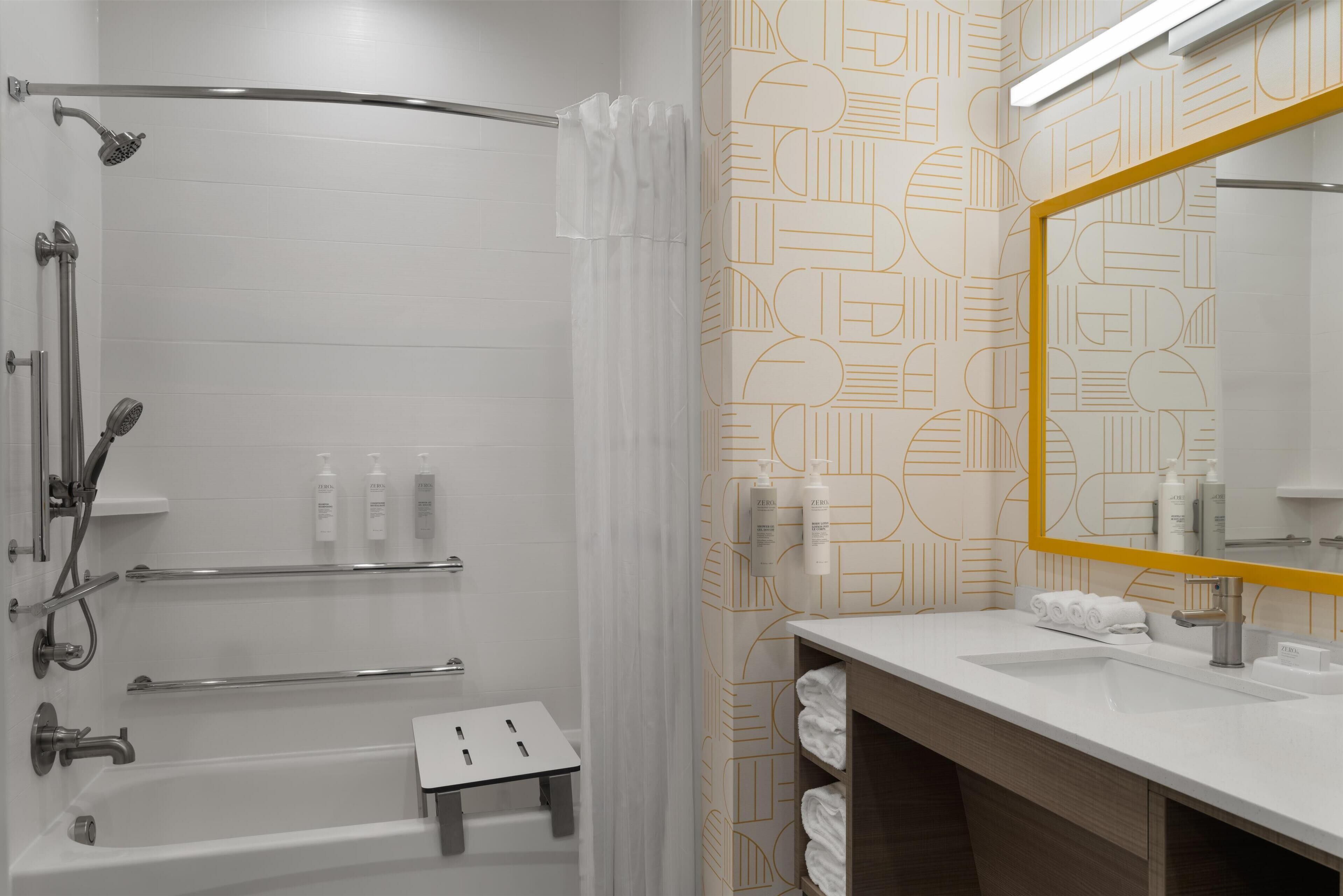 A modern bathroom with a shower, a bathtub, a vanity with a mirror, and a towel rack.