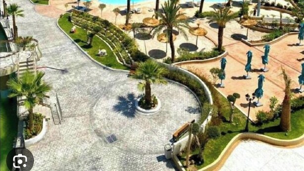 A resort with a large central pool, multiple smaller pools, and a variety of sun loungers and umbrellas. - Pool-view apartment in a charming, well-secured residence (Monastir)