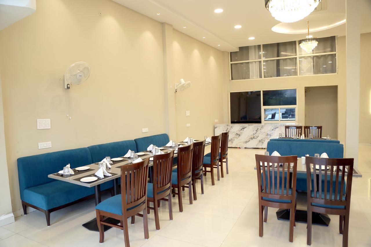 A dining area with blue upholstered seating, wooden tables, and chairs.