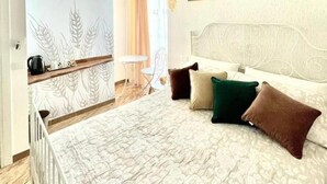 A bedroom with a large bed, a headboard, a hanging light fixture, and a wall with a textured pattern. - GRANORO B&B (Gragnano)