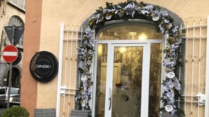A storefront with a glass door, decorated with white flowers and a sign reading "GRANORO". - GRANORO B&B (Gragnano)