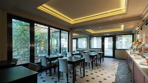 A modern dining area with large windows, tiled flooring, and contemporary lighting. - Garibaldi Palace (Milan)