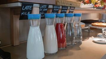 Estación de café con dispensadores de leche etiquetados para latte, leche de soya y leche de almendras.