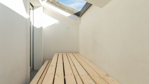 A narrow, sunlit room with a wooden bench and a skylight. - Garibaldi Palace (Milan)