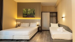 A hotel room with two beds, a painting of a forest on the wall, and a wardrobe. - Garibaldi Palace (Milan)