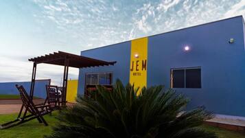 A building with a blue exterior and a yellow vertical sign that reads 'JEM HOTEL.'