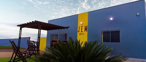 A building with a blue exterior and a yellow vertical sign that reads 'JEM HOTEL.'
