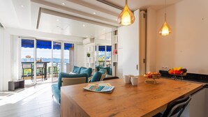 Una cocina moderna con una isla de madera, estanterías empotradas y vistas al exterior.