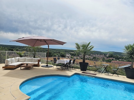 Una piscina al aire libre de temporada, sombrillas