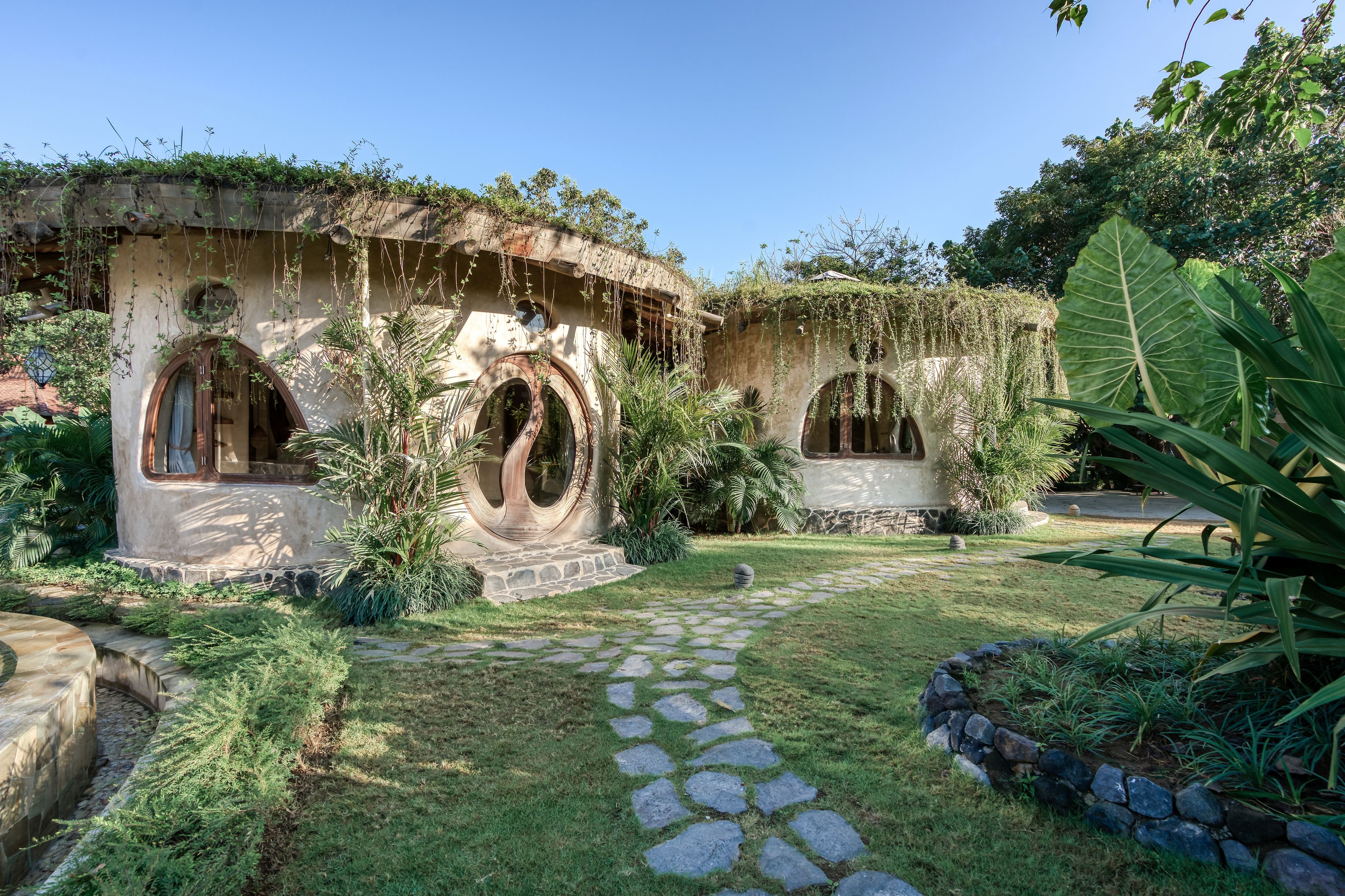 A garden with stone pathways, arched structures, and lush greenery.