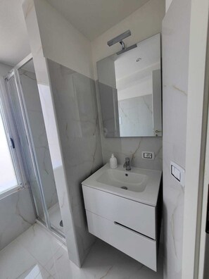 Apartament familiar | Bany | Dutxa, articles de tocador gratuïts, assecador de cabells i barnussos 