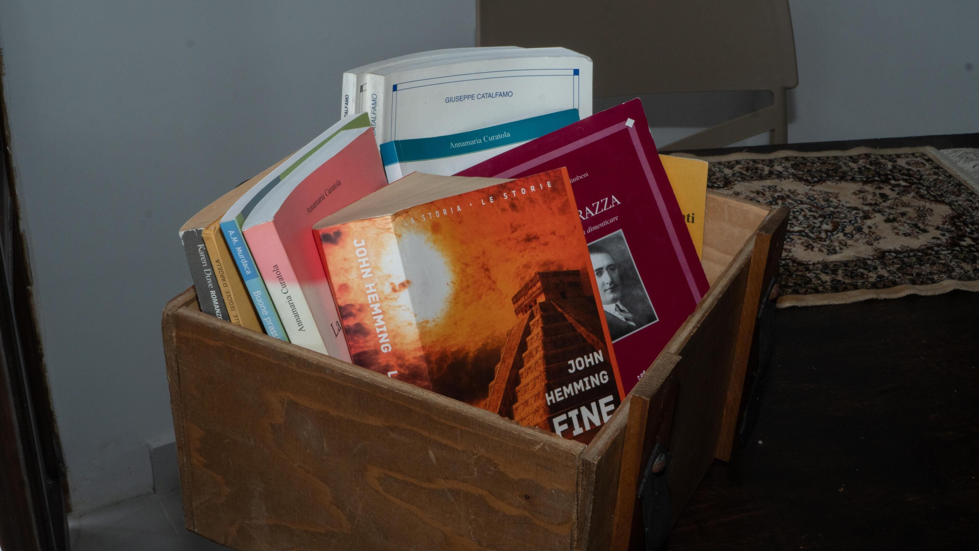 Una scatola di legno piena di libri.